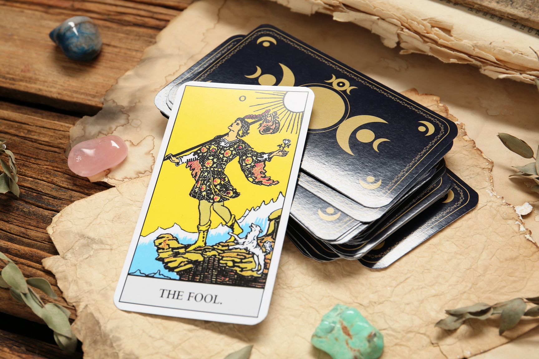 The Fool near Other Tarot Cards with Gemstones and Old Book on W